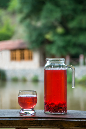carafe with berry juice on a wooden board in natureの写真素材