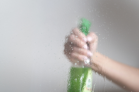 cleans the glass with a spray bottleの写真素材