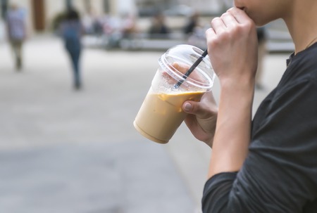 Girl holding take away cup with latteの写真素材