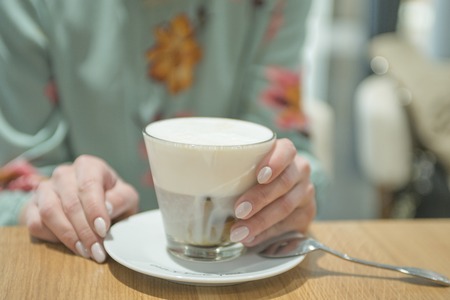 girl drinking latte coffee in a cafeの写真素材