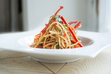 vegetarian salad with pepper and carrot on wooden tableの写真素材