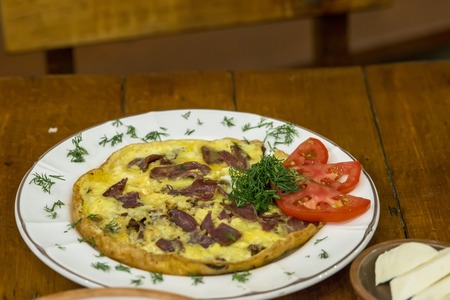 Breakfast with eggs and meat on a white plate