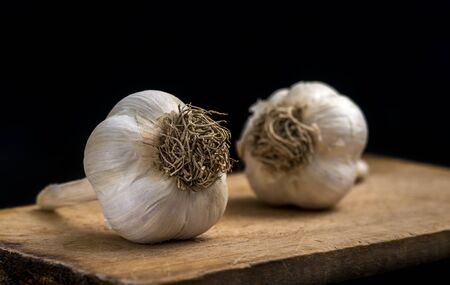 Garlic on wooden board on blackの写真素材
