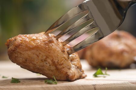Piece of chicken meat on a fork, food conceptの写真素材