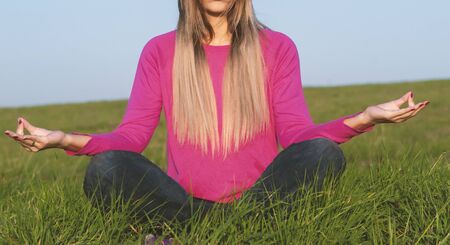 Back light of a woman exercising yoga at sunset with a warmth backgroundの写真素材