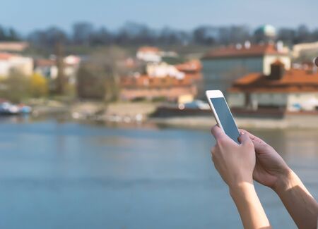 Young woman using phone outdoor in european cityの写真素材