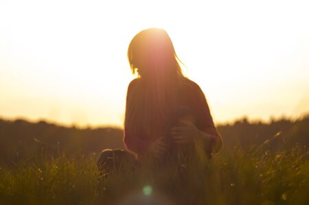 young woman on the sunrise background. Artistic toning.の写真素材