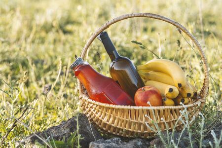 Picnic basket with food on green lawn .の写真素材