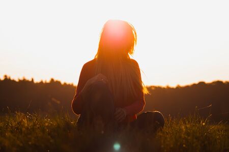 young woman on the sunrise background. Artistic toning.の写真素材