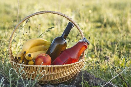 Picnic basket with food on green lawn .の写真素材