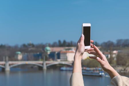young woman using phone outdoor in european cityの写真素材