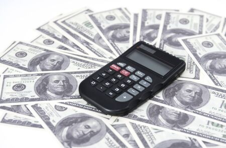 A few dollars and a calculator on the table, finance and savings.Business conceptの写真素材