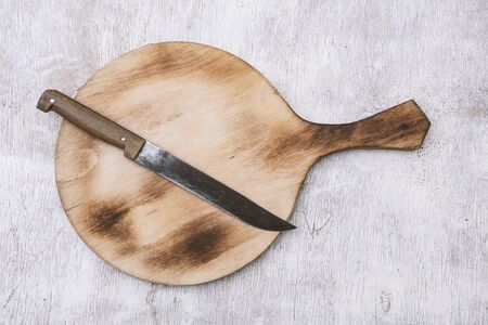 cutting board and knife on a white wooden table.view from aboveの写真素材