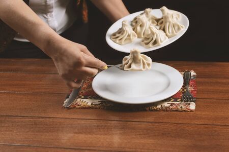 Waiter brings a plate of khinkali.の写真素材