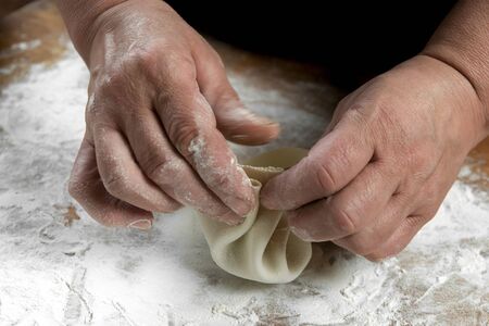 Chef cook making khinkali  on wooden table. Process preparation georgian meal. food concept.の写真素材