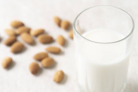 Healthy vegan nut milk and almonds on white wooden background. Selective focus, space for text.の写真素材