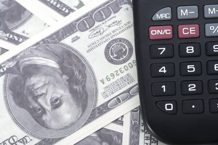 A few dollars and a calculator on the table, finance and savings.Business concept
