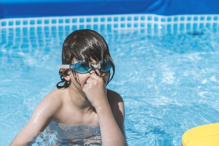 little cute boy playing in the poolの写真素材