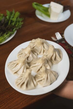 Georgian dumplings Khinkali with meat, greens  on white plateの写真素材