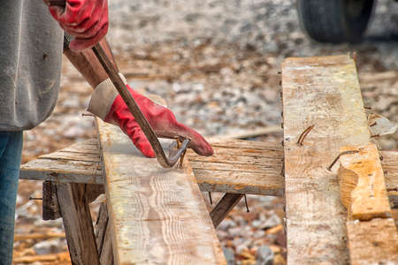 a working carpenter in dirty clothes works at a construction site