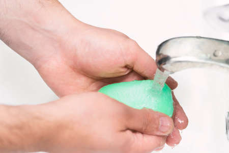 A man washes hands with soap in the bathroom. The best defense against viral infection of the crown....