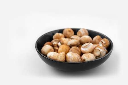 mushrooms champignon in bowl on white backgroundの写真素材