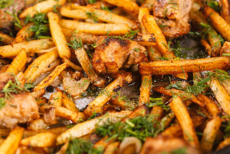 Roasted meat and potatoes in an iron pan