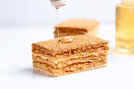 Slice of homemade honey cake on white background.の写真素材