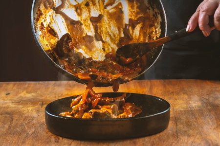 The cook prepares meat with vegetables and onion in a bowl. Oriental cuisineの写真素材