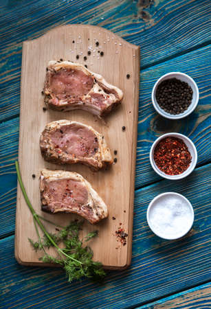 Fresh pork with ingredients for cooking on blue background. top viewの写真素材