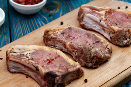 Raw pork meat on a cutting board and spices.