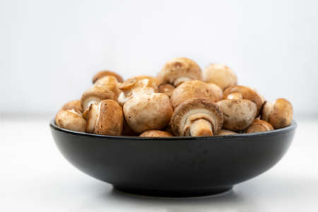 mushrooms champignon in bowl on white backgroundの写真素材