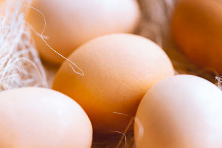 Eggs with hay in wooden box on rustic fabric. Top view food composition. Chicken eggs. Easter concept with copy space for text.の写真素材