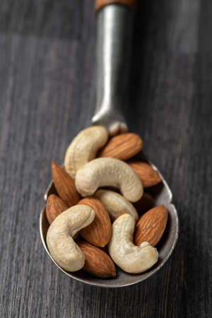 nuts in big vintage silver spoon. almondの写真素材