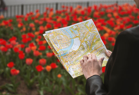 woman tourist looking at a map in a european city parkの写真素材