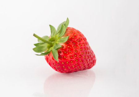 Fresh organic strawberries on a white reflective surface. close up shot.の写真素材