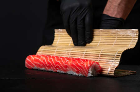 Making sushi and rolls at. Close up of a man's handの写真素材