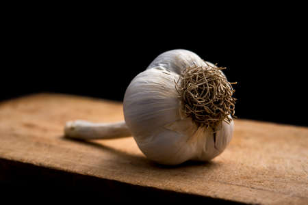 garlic on wooden board on black backgroundの写真素材