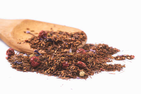 aromatic dry tea with berries on a wooden spoon isolated on white backgroundの写真素材