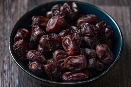Mix of dates and nuts in plate on a white wood background .healthy foodの写真素材
