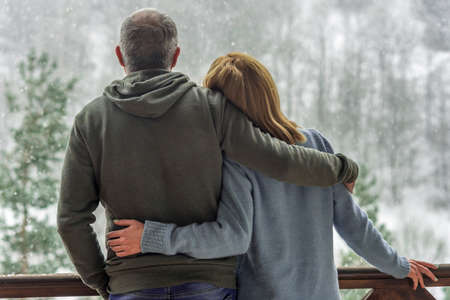 happy couple relax at balcony terrace with mountains view,Winter, Christmas.view from the backの写真素材