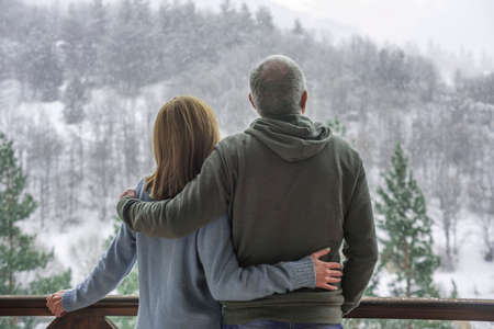 happy couple relax at balcony terrace with mountains view,Winter, Christmas.view from the backの写真素材