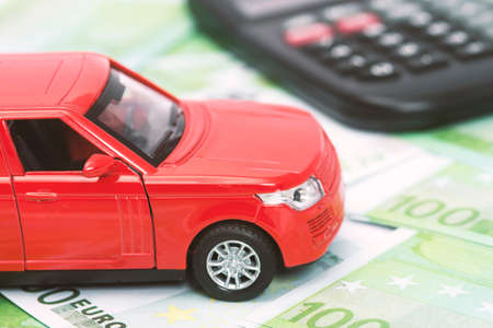 red car and money, euro and dollars. insurance conceptの写真素材