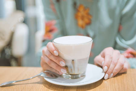 girl drinking latte coffee in a cafeの写真素材