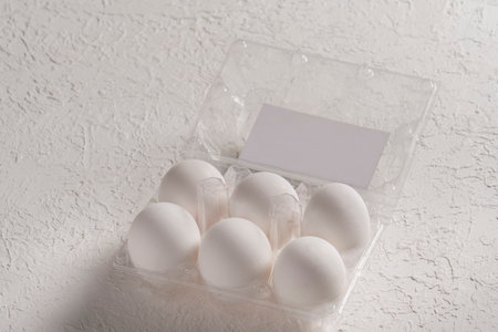 Open box with six whole white eggs on white background with clipping path. Fresh organic chicken...