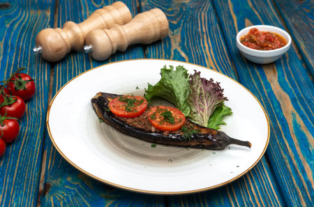 Homemade baked eggplant served with cherry tomatoes, pepper and chili sauceの写真素材