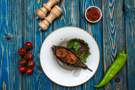 Homemade baked eggplant served with cherry tomatoes, pepper and chili sauceの写真素材