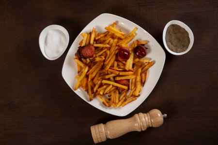 Potatoes with sausages, cut into slices and fried in oil, in rustic style. Fried potatoes with...