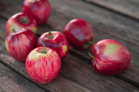Ripe red apples on wooden background.