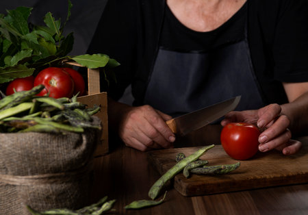 woman cutting vegetables on wooden boardの写真素材